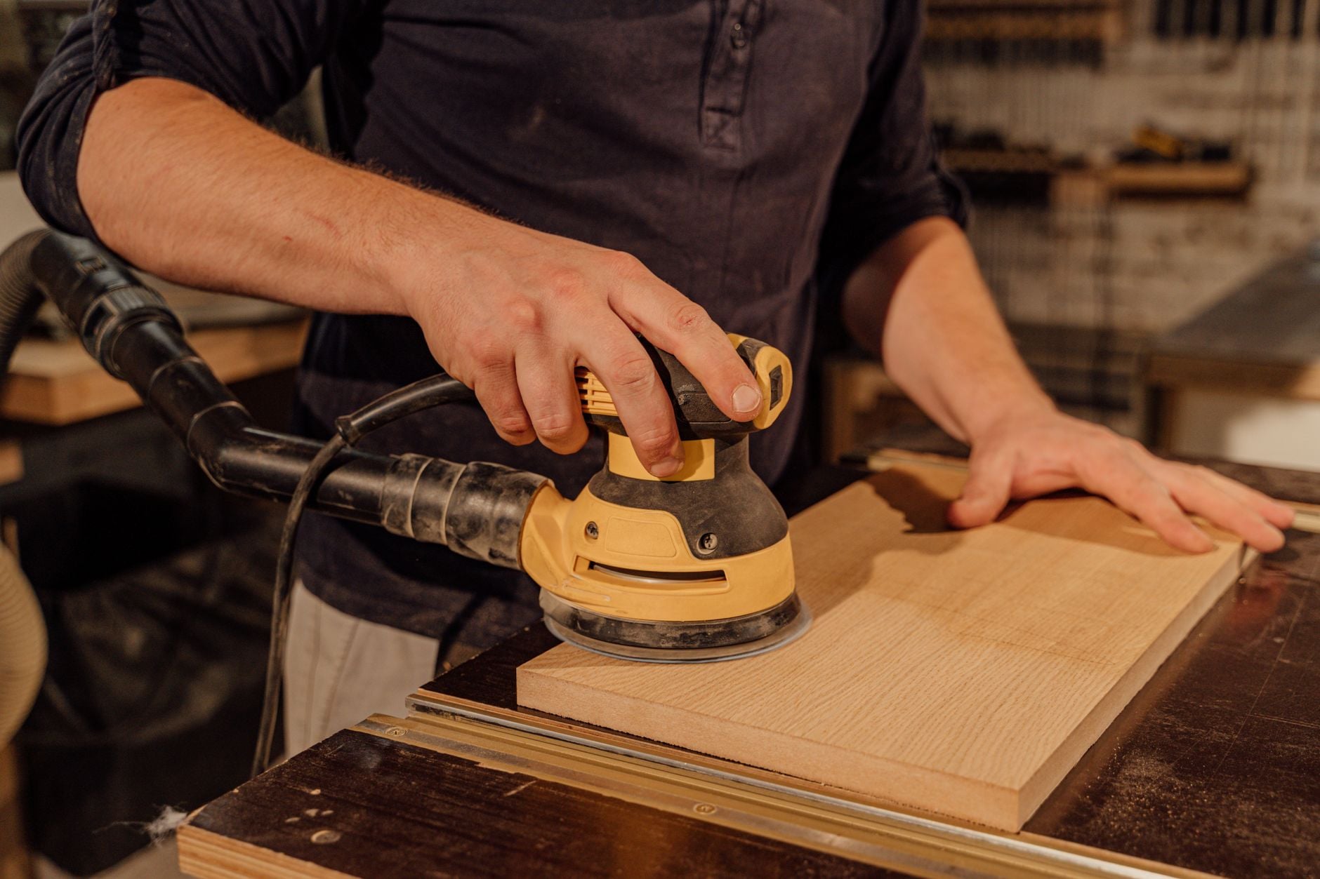 A carpenter sanding a board