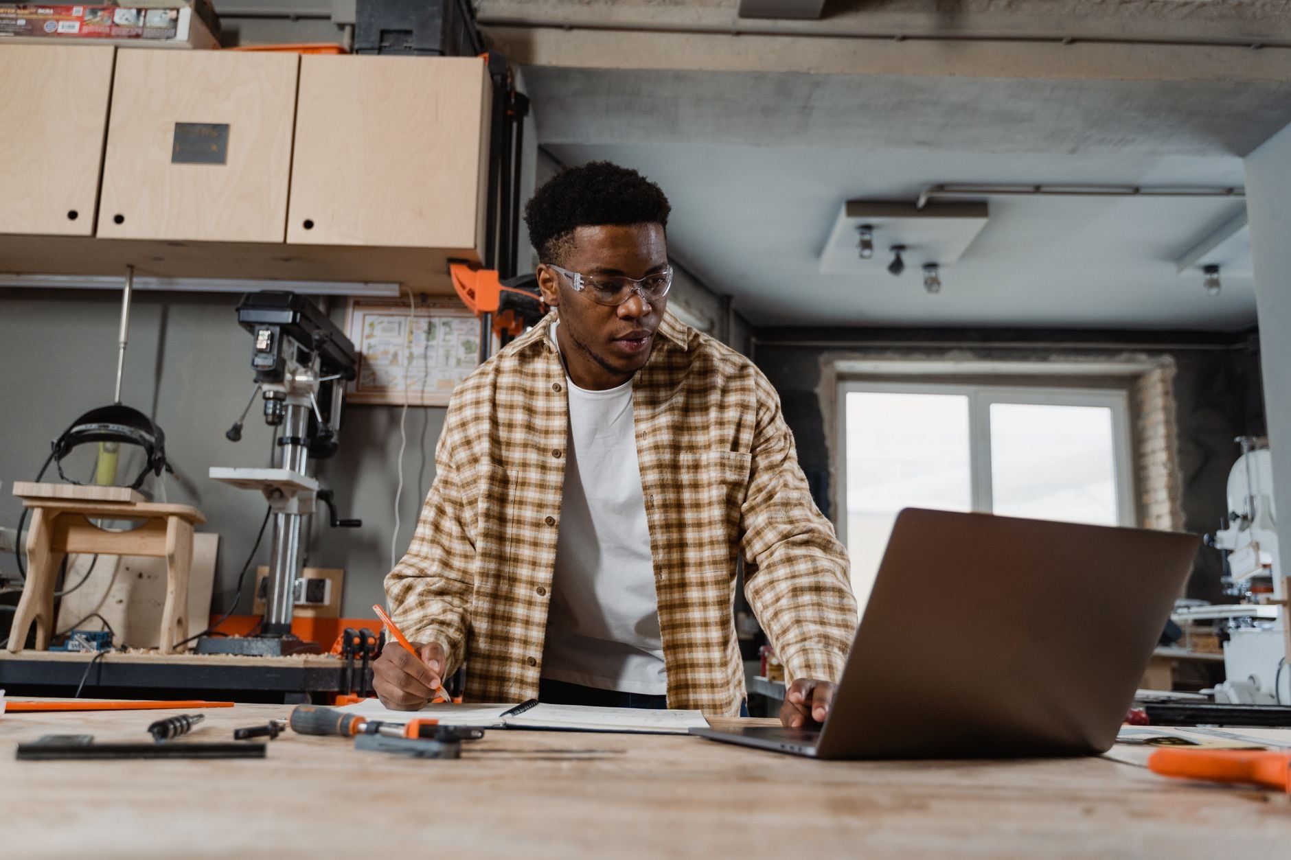 A man working at a laptop in a workshop