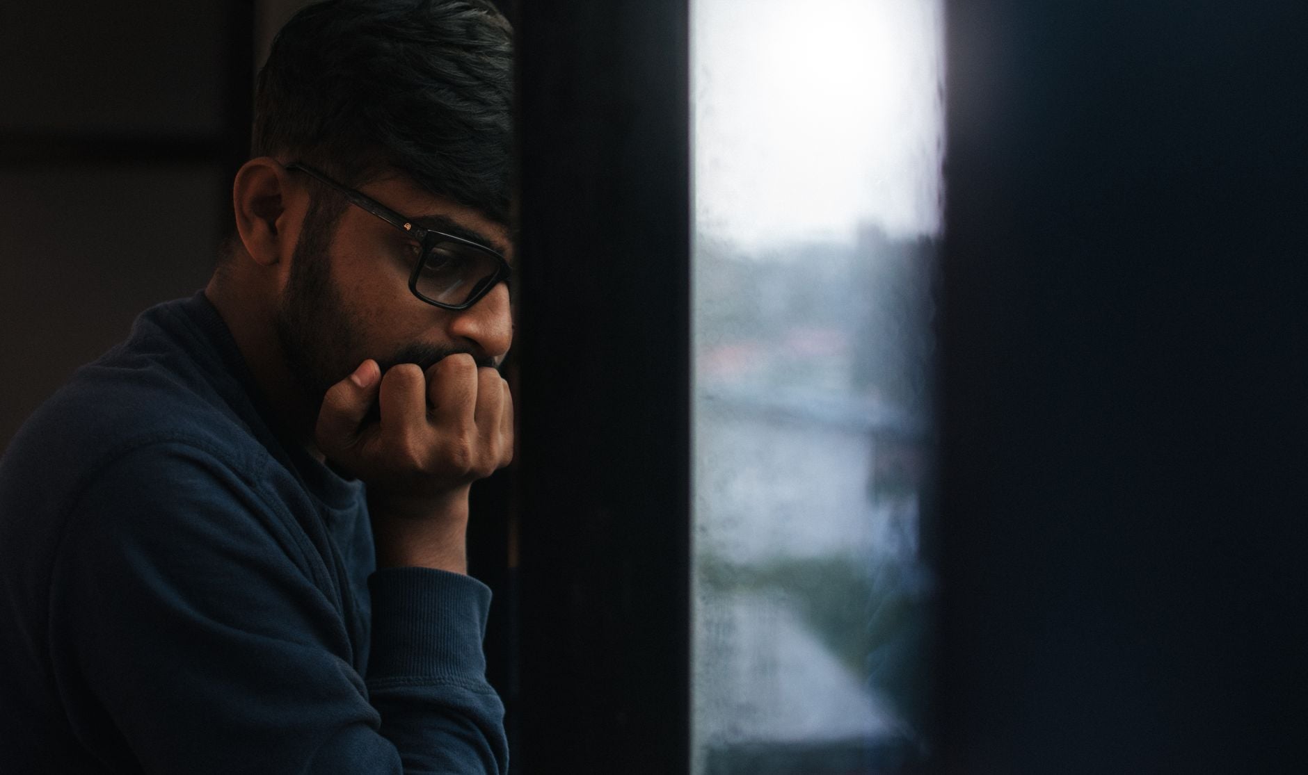 A man in profile, resting his chin on his hand