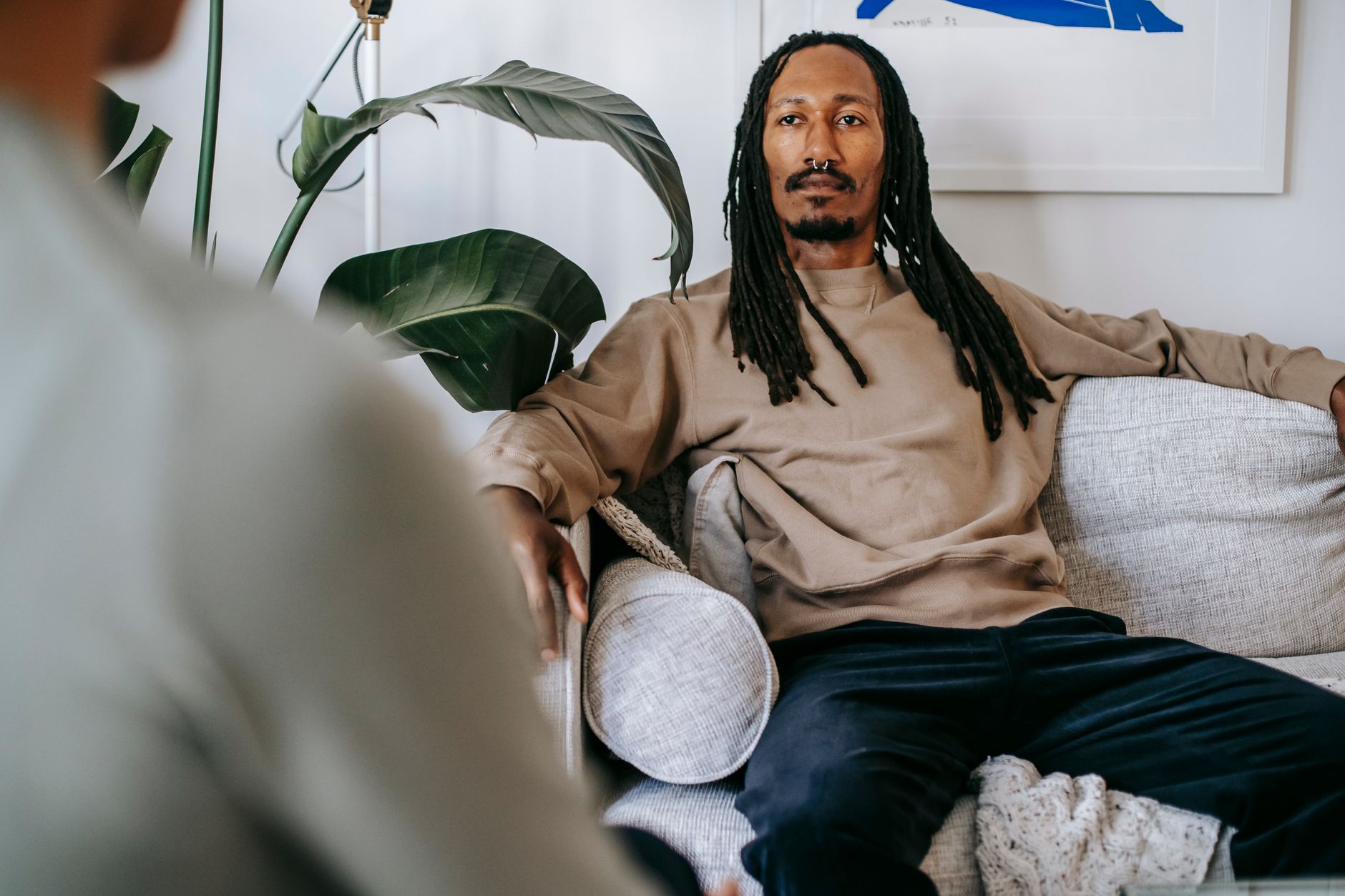 A man sitting back on a couch, thinking