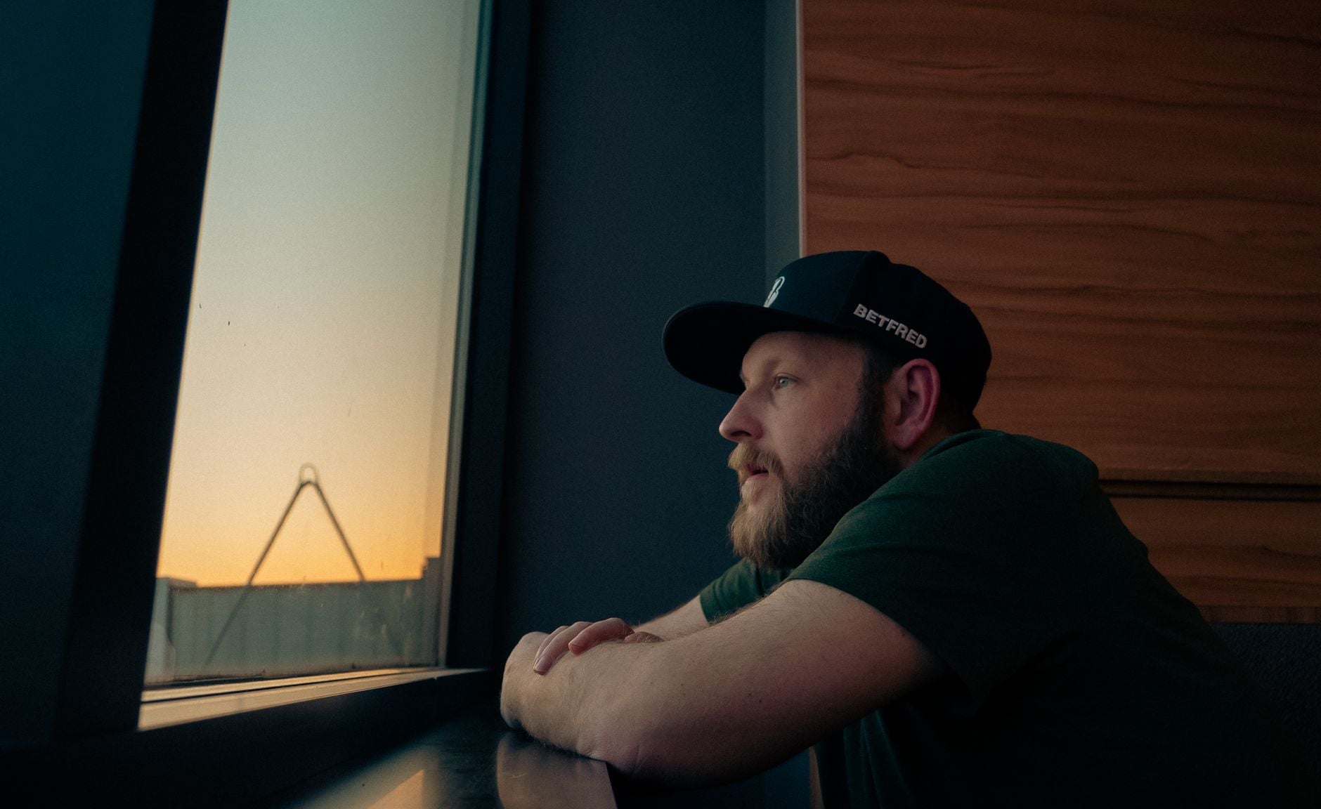 A man looking out of a window at dusk