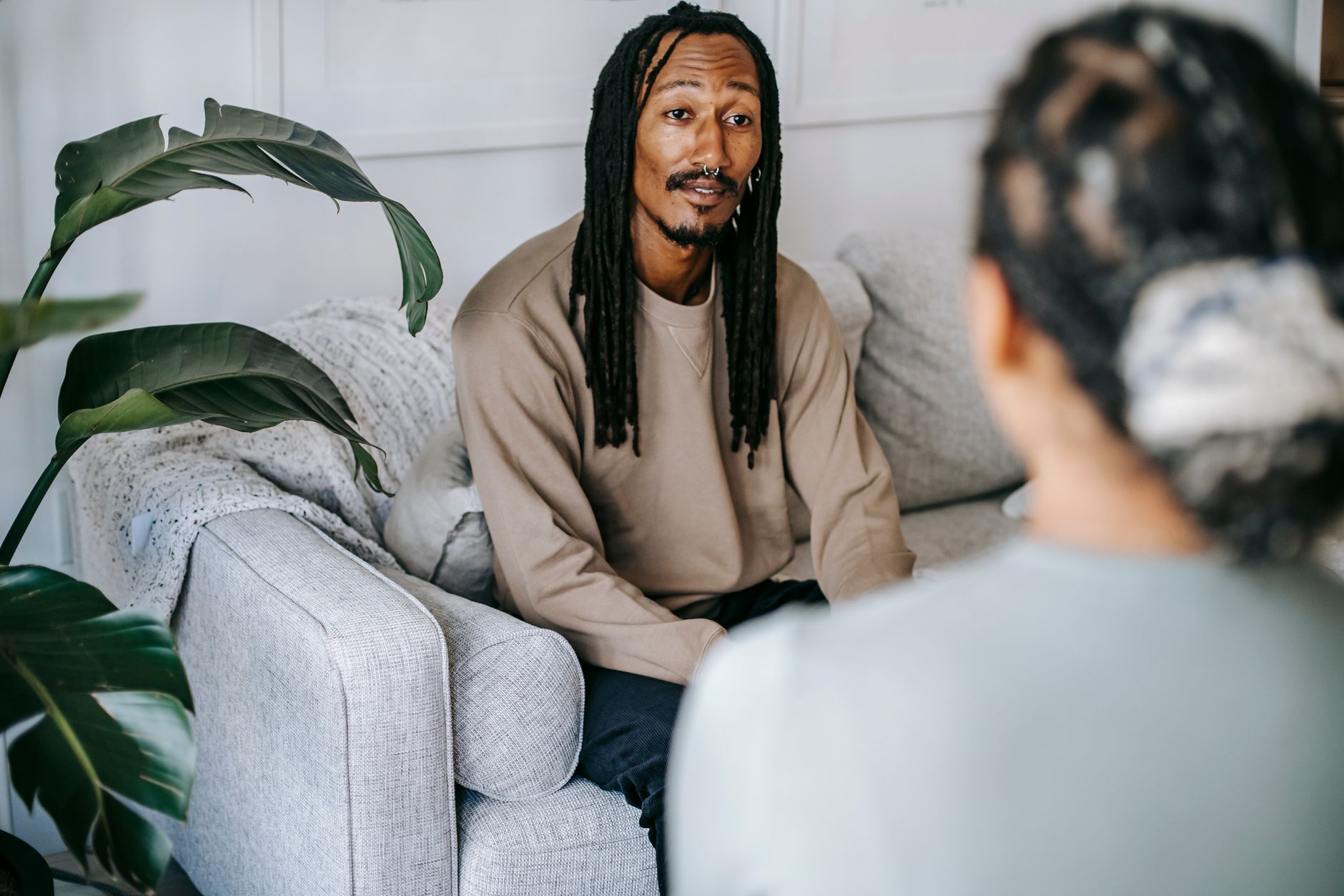 A man in conversation with someone on a couch